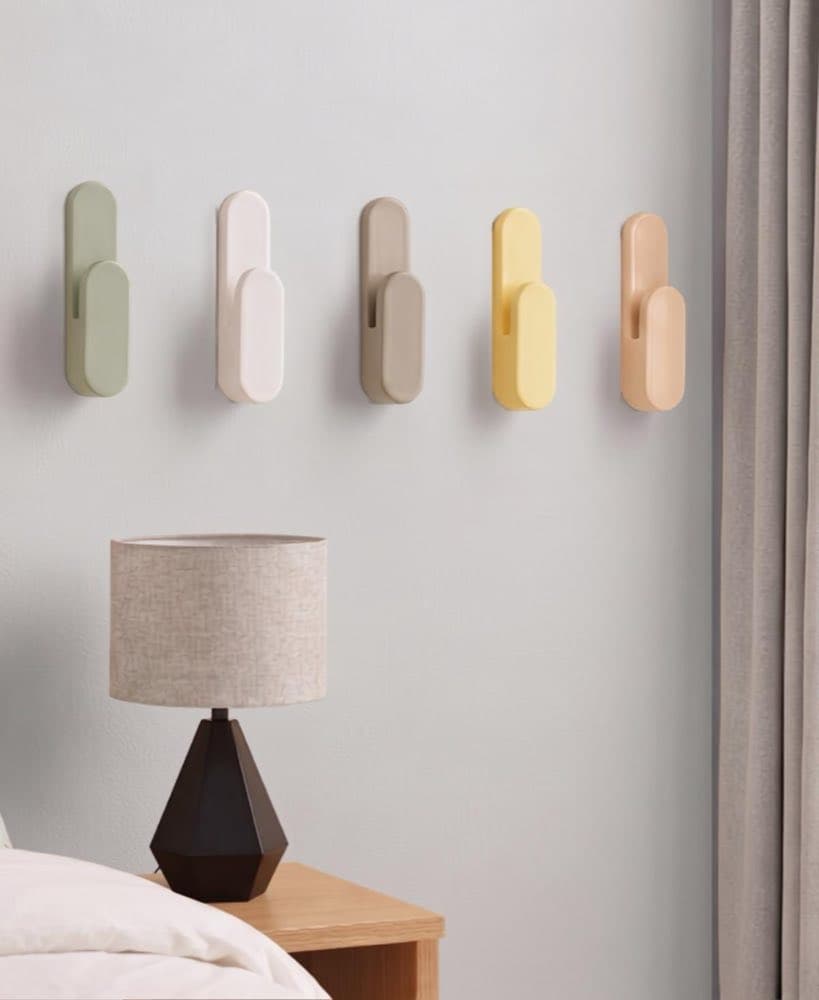 Set of minimalist wall hooks with soft curves mounted on a wall