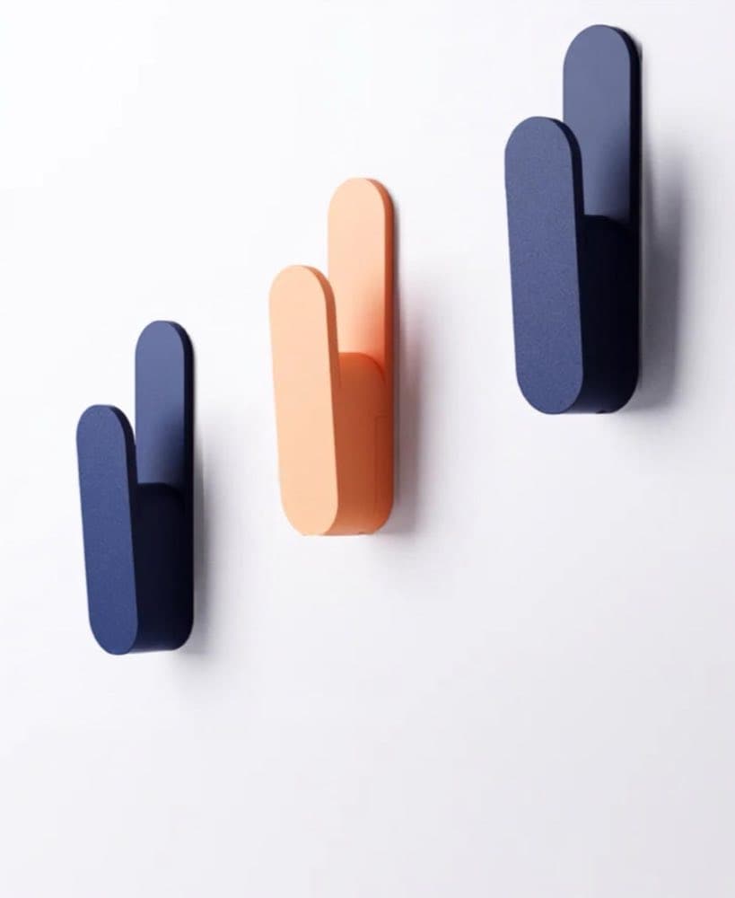 Set of minimalist wall hooks with soft curves mounted on a wall